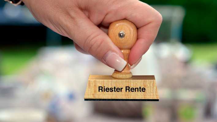 Frauenhand mit Stempel mit der Aufschrift Riester Rente