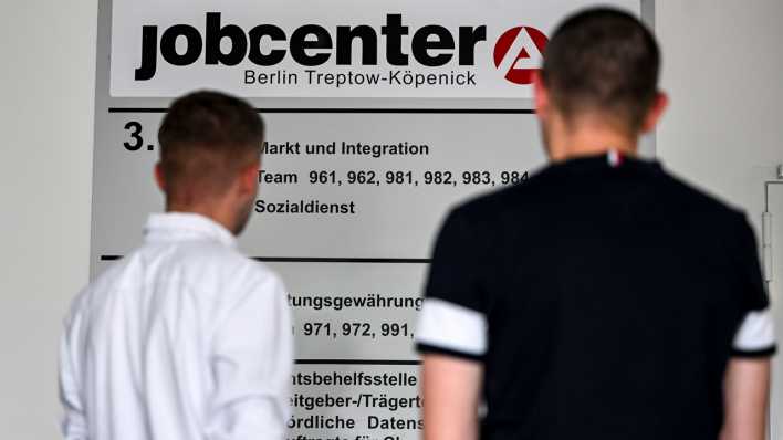 Zwei Männer stehen vor einer Tafel im Jobcenter Treptow-Köpenick
