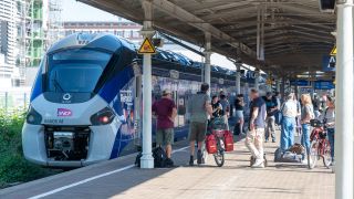 Menschen stehen auf Gleis 10 im Hauptbahnhof Trier.