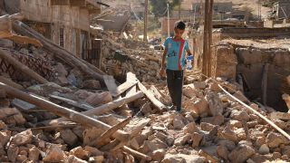 Ein Junge läuft in der Nähe des Epizentrums eines Erdbebens durch Trümmer.