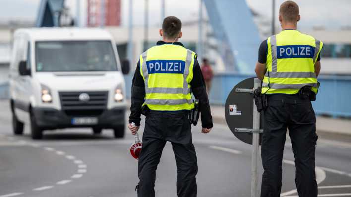 Symbolbild: Zwei Polizisten stehen an der deutsch-polnischen Grenze
