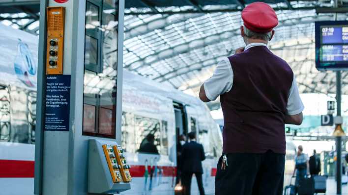 Ein Schaffner steht an einem Bahngleis des Berliner Hauptbahnhofs. (Quelle: Picture Alliance)
