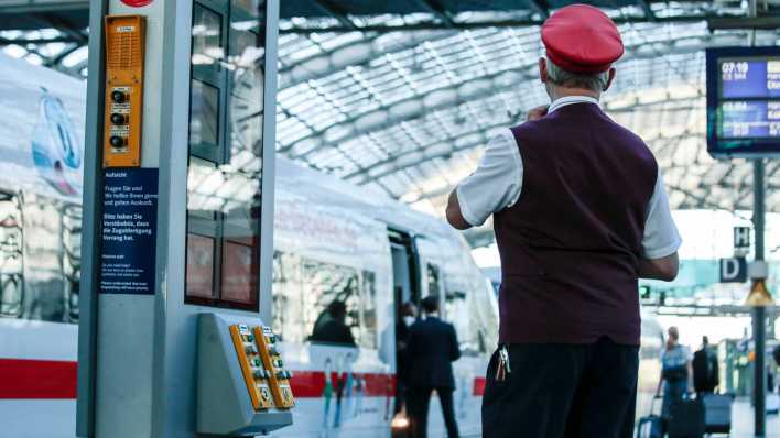 Ein Schaffner steht an einem Bahngleis des Berliner Hauptbahnhofs. (Quelle: Picture Alliance)