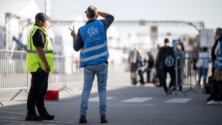 Helfer und Sicherheitskräfte stehen in der Notunterkunft für Geflüchtete am ehemaligen Flughafen Tegel.