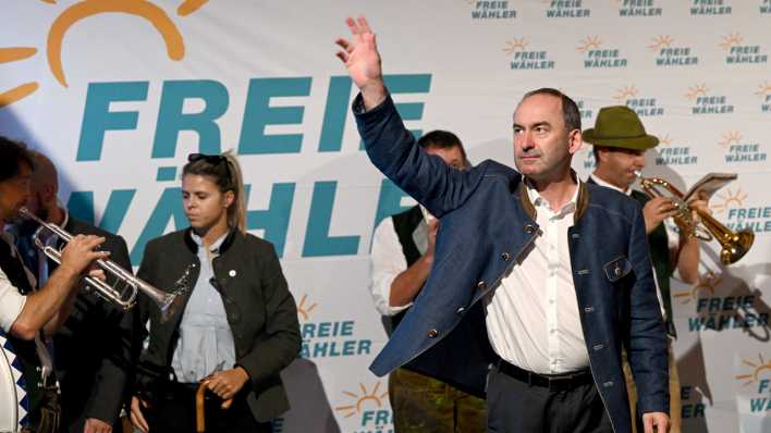 Hubert Aiwanger (vorn), stellvertretender Ministerpräsident von Bayern, winkt auf der Bühne (Bild: dpa)