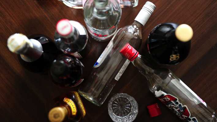 Symbolfoto Alkoholismus: Leere Schnapsflaschen stehen auf dem Boden.