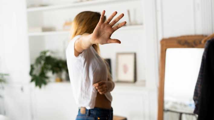 Symbolfoto: Ein Frau hält abwehrend eine Hand der Kamera entgegen.