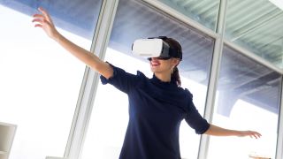 Eine Frau benutzt eine Brille für virtuelle Realität (Bild: picture alliance / Zoonar)