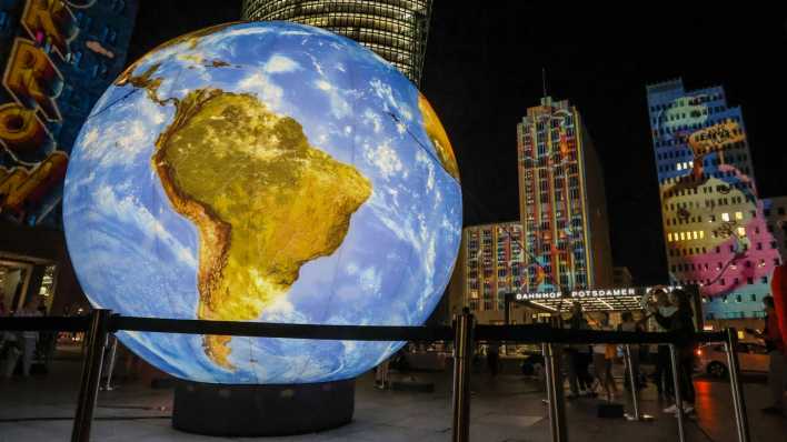Ein Globus ist in Berlin erleuchtet zum Festival of Lights am Potsdamer Platz.
