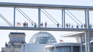 Menschen laufen über den Marie-Elisabeth-Lüders-Steg im Berliner Regierungsviertel.