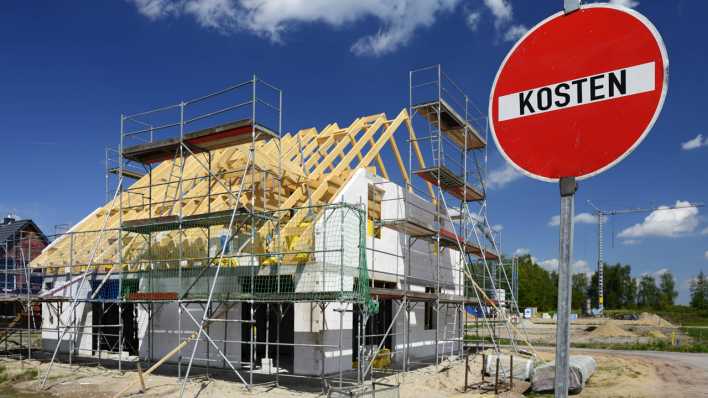 Neubau eines Hauses und Schild mit Aufschrift Kosten