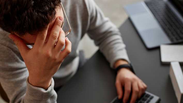 Gestresster Mitarbeiter am Computer