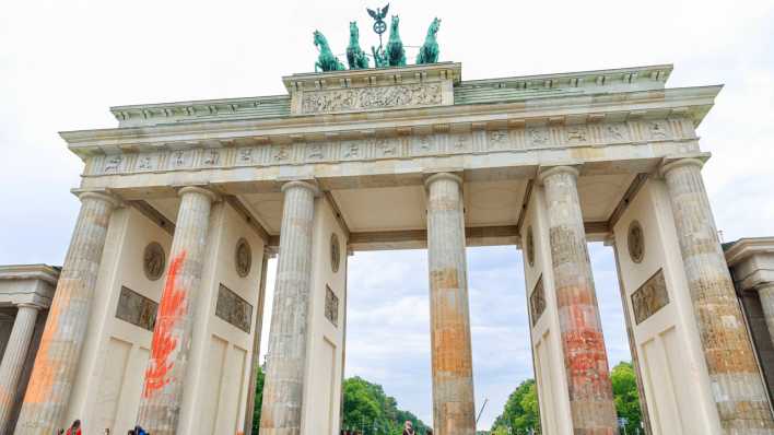 Schmiererei am Brandenburger Tor nach einem Farbanschlag von Klimaaktivisten