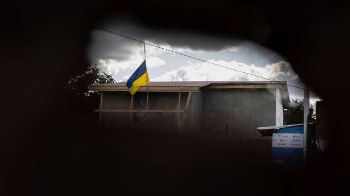 Eine ukrainische Flagge ist durch ein Loch zu sehen.