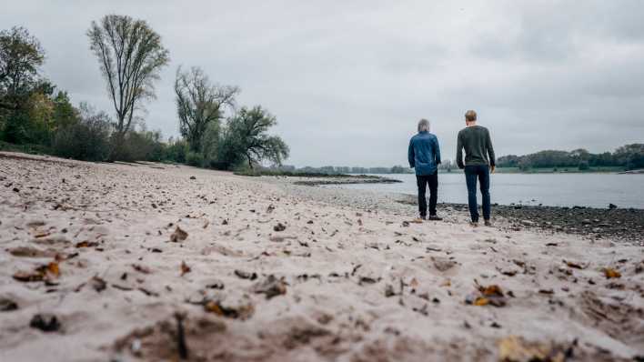 Zwei Freunde unterhalten sich an einem Fluss