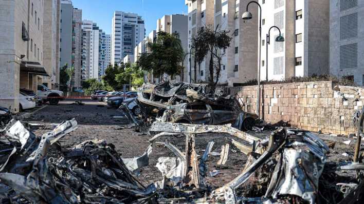 Autotrümmerl liegen nach schweren Angriffen der Hamas auf der Straße