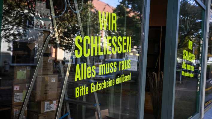 An der Fensterscheibe eines Geschäfts ist „Wir schliessen. Alles muss raus. Bitte Gutscheine einlösen!“ zu lesen.