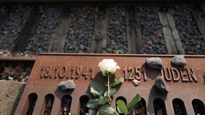 Eine Blume liegt in Gedenken an den Beginn der nationalsozialistischen Deportationen von Juden am Gleis 17 im Bahnhof Grunewald in Berlin (Bild: picture alliance / Jörg Carstensen/dpa)