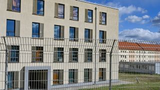 Ein hoher Zaun umgibt die Erstaufnahme-Einrichtungen des Landes Brandenburg in Eisenhüttenstadt (Bild: dpa / Patrick Pleul)