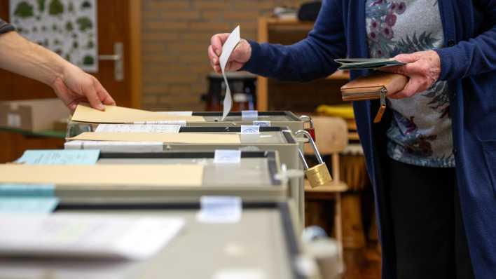 Ein Frau wirft ihren Stimmzettel in die Wahlurne.