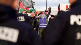 Polizisten stehen vor pro-palästinensische Demonstranten.