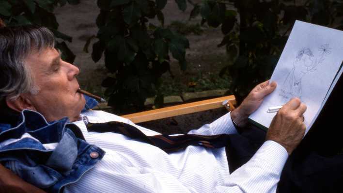 Vicco von Bülow zeichnet während einer Drehpause von "Ödipussi" eine Knollennasen-Figur (Aufnahme von 1987).