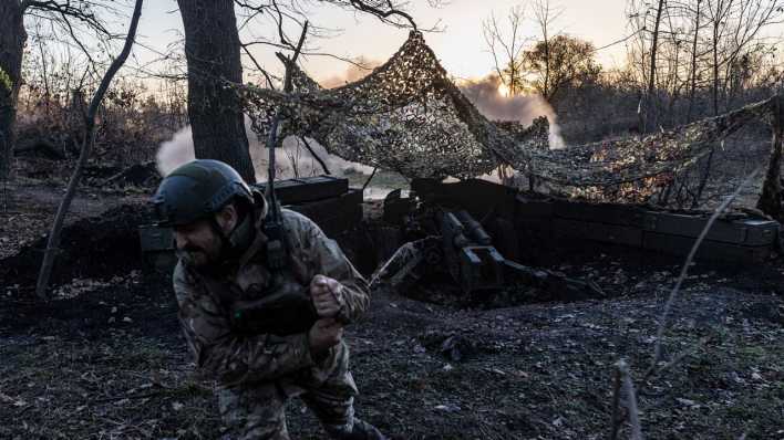 Ein ukrainischer Soldat feuert eine Artilleriegeschoss ab.