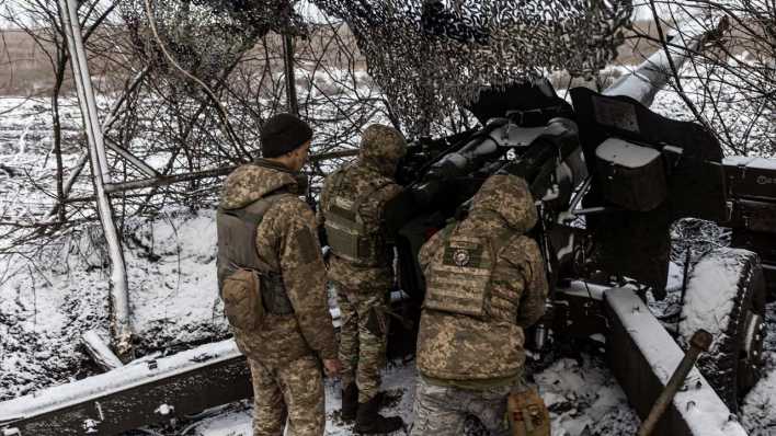 Ukrainische Soldaten bereiten eine Waffe vor, es liegt Schnee.