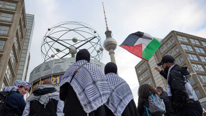 Teilnehmer einer pro-palästinensischen Kundgebung sind mit Fahnen auf dem Alexanderplatz in Berlin unterwegs. (Bild: dpa/ Jörg Carstensen)