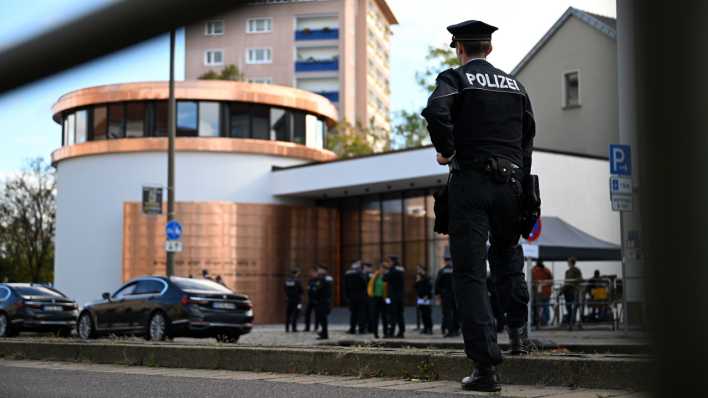 Ein Polizist schaut während der Einweihung der neu erbauten Synagoge in Dessau schaut von der gegenüberliegenden Straßenseite auf den Eingang der Synagoge (Bild: dpa / Hendrik Schmidt)