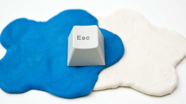 Eine Taste mit Escape-Symbol liegt auf einer weißen und einer blauen Wolke aus Knete (Bild: picture alliance / dpa Themendienst | Andrea Warnecke)