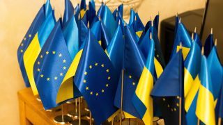 Kleine ukrainische und europäische Flaggen sind auf einem Tisch zu sehen.