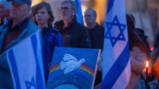 Kerzen, Plakate und israelische Flaggen bei einer Demonstration für die Opfer der Angriffe der Hamas in Stralsund.