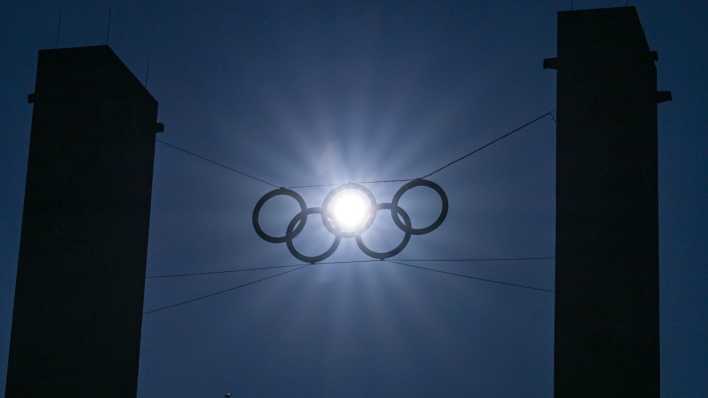 Die tiefstehende Sonne scheint durch einen der fünf Ringe über dem Eingang zum Berliner Olympiastadion (Bild: dpa / Soeren Stache)