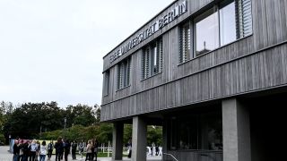 Studenten gehen auf dem Gelände der Freien Universität Berlin in Richtung Hörsaal.