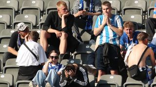 Herthafans sitzen enttäuscht nach dem Abstieg auf der Tribüne.