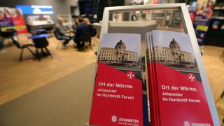 Prospekte stehen am Eingang eines Orts der Wärme der Johanniter im Humboldt Forum