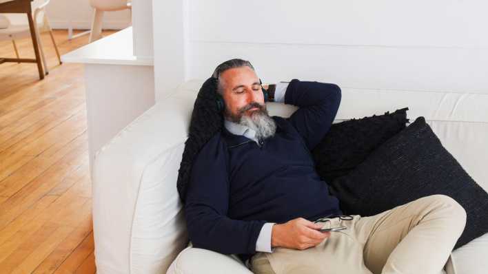 Mann liegt auf einen Sofa und hört Musik (Bild: picture alliance / Bildagentur-online/Blend Images/Strauss/Curtis)
