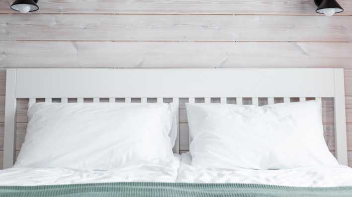 Ein frisch gemachtes Bett mit weißen Bezügen