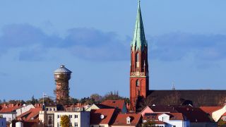 Skyline von Wittenberge: Die im Jahr 1872 erbaute evangelische Stadtkirche und der Wasserturm neben Wohn- und Geschäftshäusern
