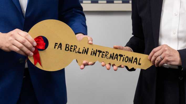 Stefan Evers (CDU, l), Finanzsenator von Berlin, übergibt bei der Eröffnung vom Finanzamt Berlin International einen symbolischen Schlüssel an Beate Penshorn (r), Amtsleiterin vom Finanzamt Berlin International.