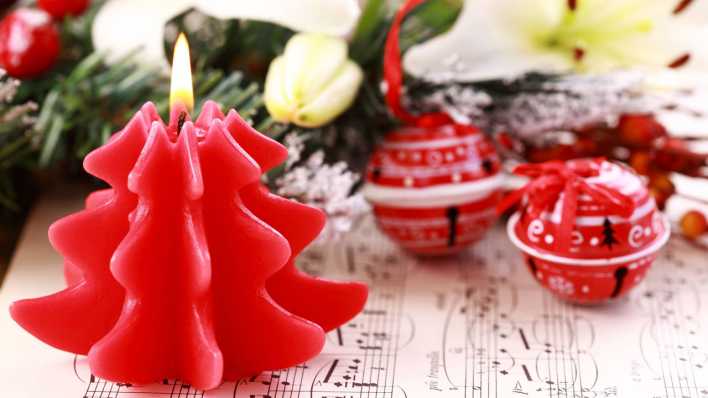 Weihnachtskerze mit Glöckchen und Noten