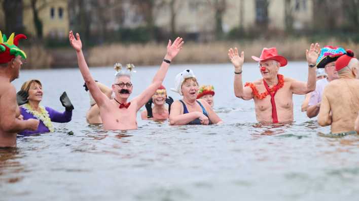 Kostümierte Winterschwimmer des Vereins "Berliner Seehunde" nehmen beim Neujahrsschwimmen im Orankesee ein Bad.