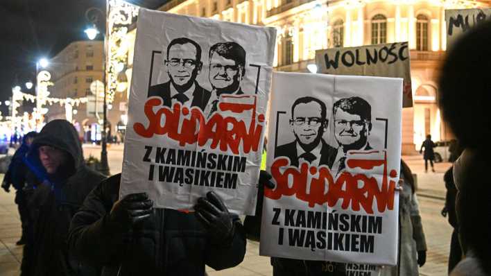 Oppositionsanhänger halten ein Porträt der beiden inhaftierten PiS-Politiker, dem ehemaligen Innenministers Kaminski und dem ehemaligen stellvertretenden Innenministers Wasik, hoch. (Bild: Radek Pietruszka/PAP/dpa)