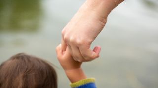 Symbolbild: Eine Mutter hält ihr Kind an der Hand