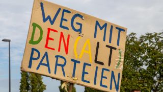 Bei einer Demo wird ein Schild mit der Aufschrift " Weg mit den Alt-Parteien" hochgehalten. (Bild: picture alliance / CHROMORANGE)