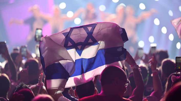 Ein Fan hält während des Eurovision Song Contests 2023 in Liverpool eine Israel-Flagge hoch (Bild: picture alliance/TT NYHETSBYR?N/Jessica Gow)