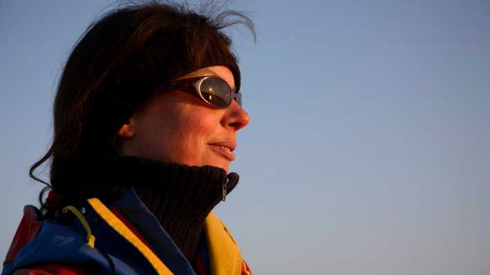 Eine Frau mit Sonnenbrille in Winterkleidung hält das Gesicht Richtung Sonne (Bild: picture alliance / Bildagentur-online/Diederich)