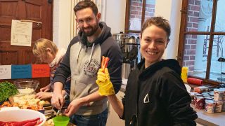 Die Freiwilligen Lena, Graham und Natalia kochen für Obdachlose.
