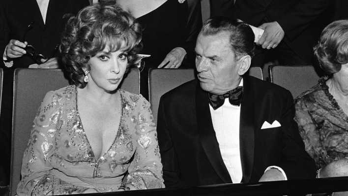 ARCHIV: Gina Lollobrigida mit Berlinale-Chef Dr. Alfred Bauer im Zoo-Palast vor der Eröffnung der Filmfestspiele 1975 in Berlin (Bild: picture-alliance)